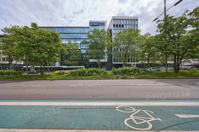 Auditing and management consultancy KPMG, modern architecture, street, public bus, cycle path, coloured lane markings, trees, milky blue sky, diffuse light, slightly sunny, Theodor-Heuss-Straße, Stuttgart, state capital, urban district of Stuttgart, Baden-Württemberg, Germany