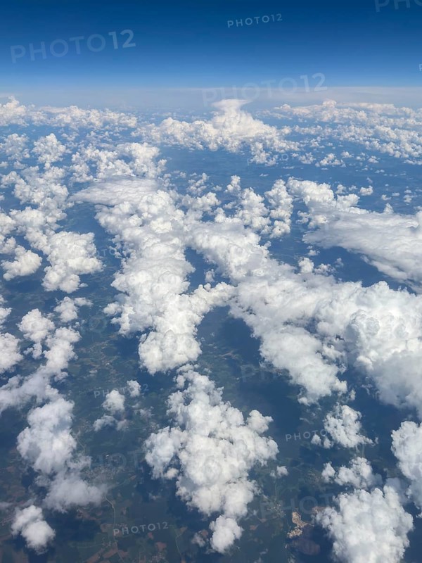 Aerial view from aeroplane at high altitude of white, bright cluster clouds Altocumulus, international