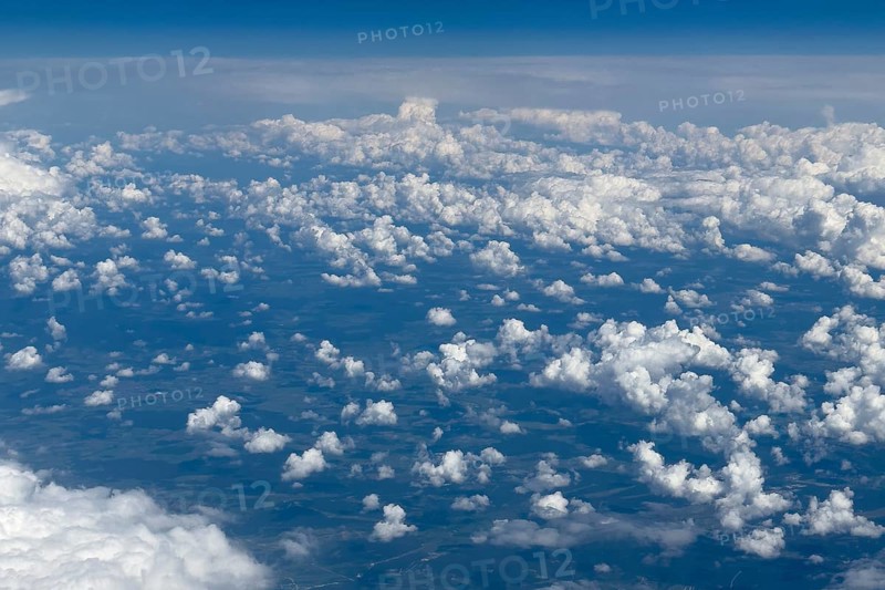Aerial view from an aeroplane at high altitude of many white, bright cluster clouds Altocumulus, international