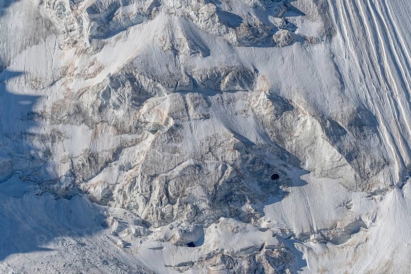 Intricate patterns of ice and rock are showcased in this stunning glacial landscape, revealing the effects of time on the frozen surface. The bright daylight emphasises the textures and colours. Gorner Glacier, Zermatt, Valais, Alps, Swiss