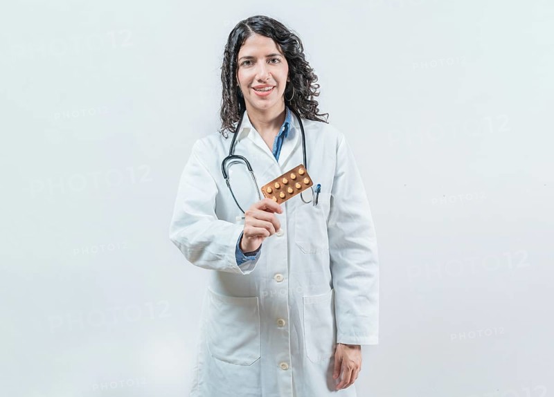 Female doctor holding pills tablet isolated. Portrait of a young female doctor showing pills tablet on isolated background