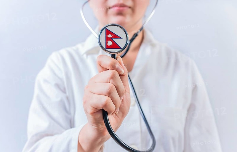 Female doctor holding stethoscope with Nepal flag. National health system of Nepal