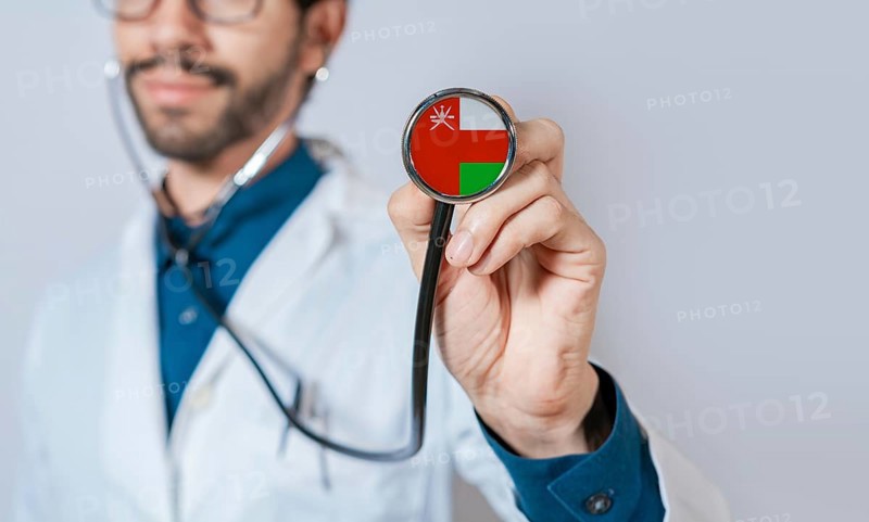 Doctor holding stethoscope with Oman flag. Oman health and care concept, Oman flag on stethoscope