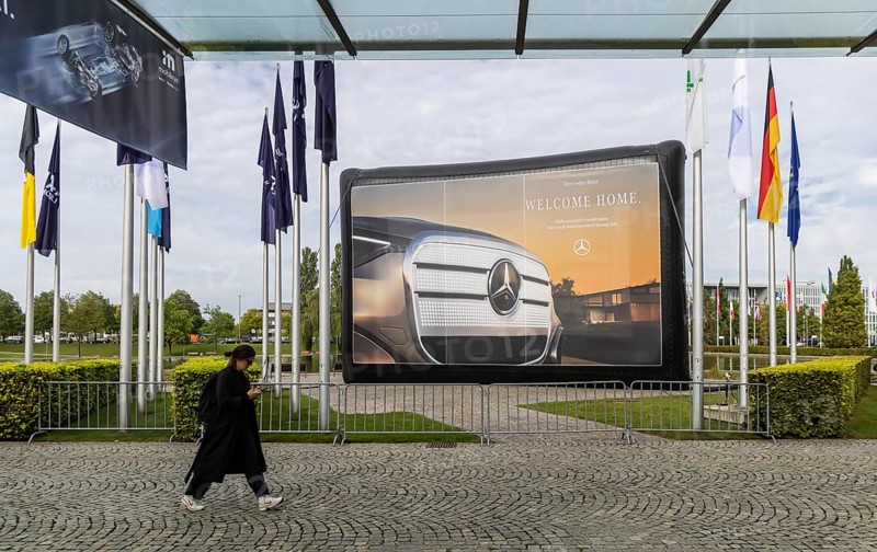 Entrance area at the exhibition halls. IAA MOBILITY in Munich. The Autoshow presents itself as a holistic mobility trade fair. But cars are still the centre of attention. Advertising banner of the Mercedes brand. Munich, Bavaria, Germany
