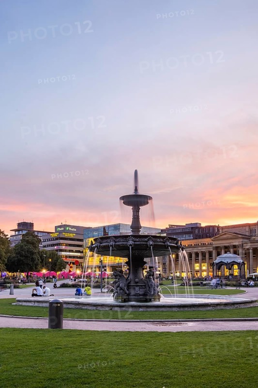 Evening atmosphere at Schlossplatz Stuttgart. View of Königstraße, art museum and Königsbau. Striking fountain with fountain bowl. Stuttgart, Baden-Württemberg, Germany