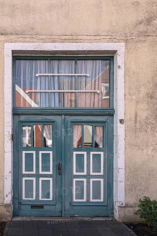 Blue wooden door with windows and white curtains on a rustic building, Old Town Burgsteinfurt, Steinfurt, Münsterland, North Rhine-Westphalia, Germany