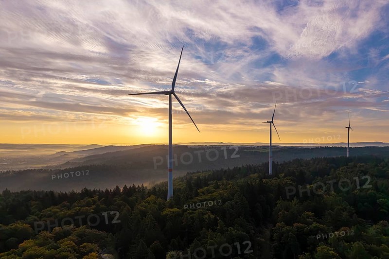 Wind turbines over a densely wooded area under a bright, clear morning sky, near Schorndorf, Rems-Murr district, Rems-Murr-Kreis, Baden-Württemberg, Germany