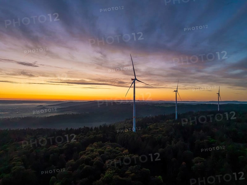 Three wind turbines on a green hill at sunrise with sweeping mountain views, near Schorndorf, Rems-Murr district, Rems-Murr-Kreis, Baden-Württemberg, Germany