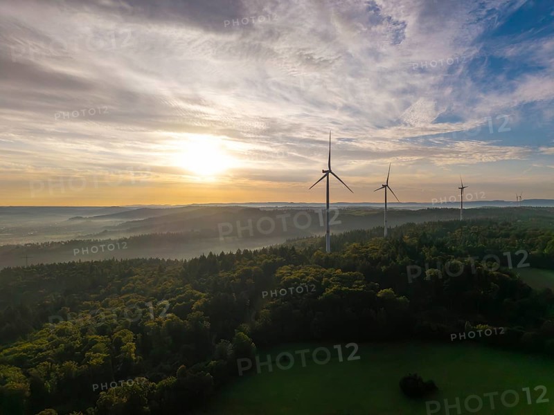 Wind turbines rise above a misty forest at sunrise, a symbol of renewable energy in a peaceful landscape, near Schorndorf, Remstal, Rems-Murr-Kreis, Baden-Württemberg, Germany