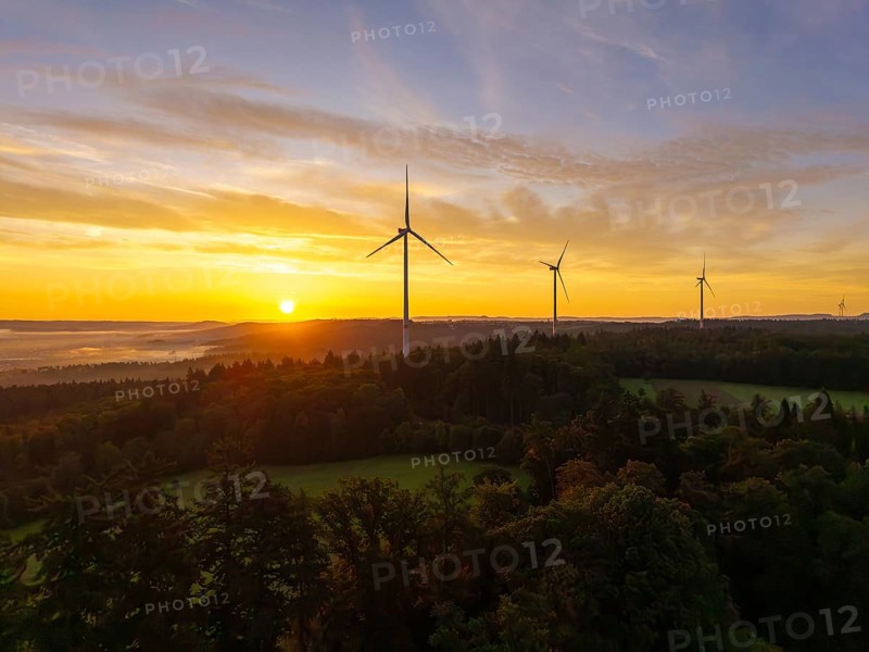 Wind turbines in a hilly and wooded landscape, illuminated by the rising sun, near Schorndorf, Remstal, Rems-Murr-Kreis, Baden-Württemberg, Germany
