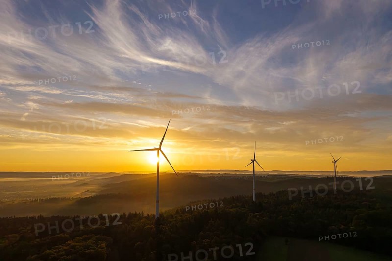 Wind turbines rise in front of a sunrise over a green landscape, creating a tranquil atmosphere, near Schorndorf, Rems-Murr district, Rems-Murr-Kreis, Baden-Württemberg, Germany