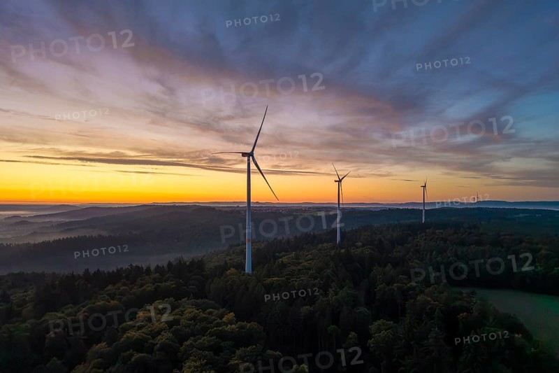 Three wind turbines on a wooded hill with a dramatic sunrise sky, near Schorndorf, Remstal, Rems-Murr-Kreis, Baden-Württemberg, Germany