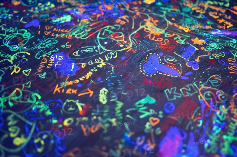 Colourful neon scribbles and graffiti on table top, arcade, Soho, London, England, Great Britain