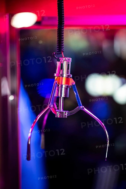 A shiny gripping arm of a vending machine, combination of vending machine and slot machine under neon-coloured light in a futuristic atmosphere, Soho, London, England, United Kingdom