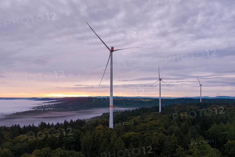 Three wind turbines above a forest at dusk under a cloudy sky, near Schorndorf, Rems-Murr district, Rems-Murr-Kreis, Baden-Württemberg, Germany