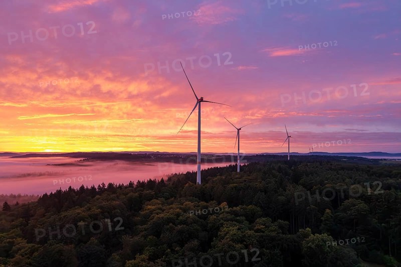 Three wind turbines above a forest in front of sunrise in a vivid colour mood, near Schorndorf, Rems-Murr district, Rems-Murr-Kreis, Baden-Württemberg, Germany