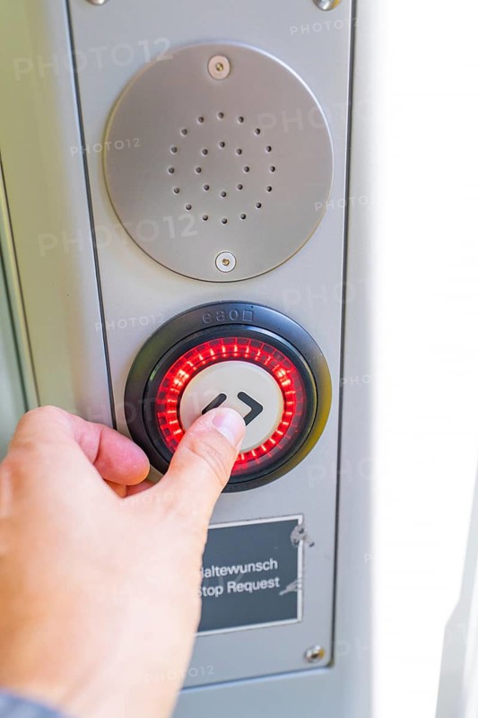 Close-up of a hand pressing a red illuminated stop button, battery Electric train with green electricity, Siemens Mireo Plus B, Freudenstadt, Germany