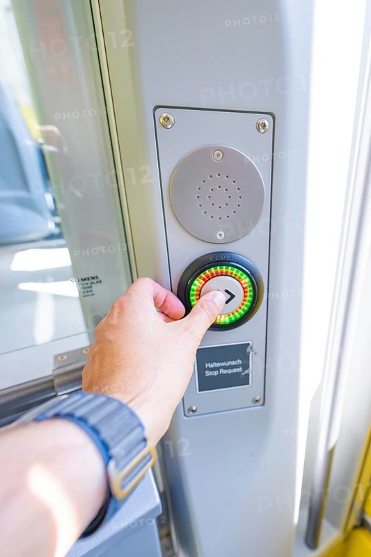 Hand presses stop button on a modern vehicle door, battery Electric train powered by green electricity, Siemens Mireo Plus B, Freudenstadt, Germany