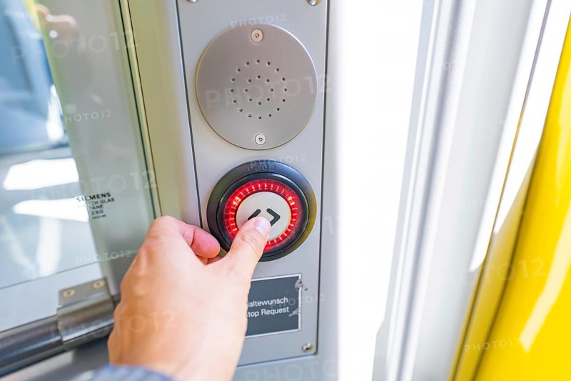 Hand operates a red illuminated stop button on a door in the vehicle, battery Electric train with green electricity, Siemens Mireo Plus B, Freudenstadt, Germany