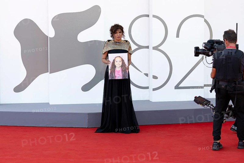 Venice, Italy - 3 September 2025: Kaouther Ben Hania with a portrait of five-year-old Palestinian girl Hind Rajab, who was killed by the Israeli army in the Gaza Strip in January 2024, during the red carpet of - The Voice Of Hind Rajab - during the 82nd Venice International Film Festival