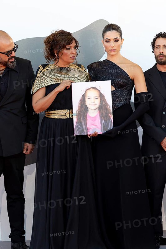 Venice, Italy - 3 September 2025: Kaouther Ben Hania and Saja Kilani with a portrait of five-year-old Palestinian girl Hind Rajab, who was killed by the Israeli army in the Gaza Strip in January 2024, during the red carpet of - The Voice Of Hind Rajab - during the 82nd Venice International Film Festival