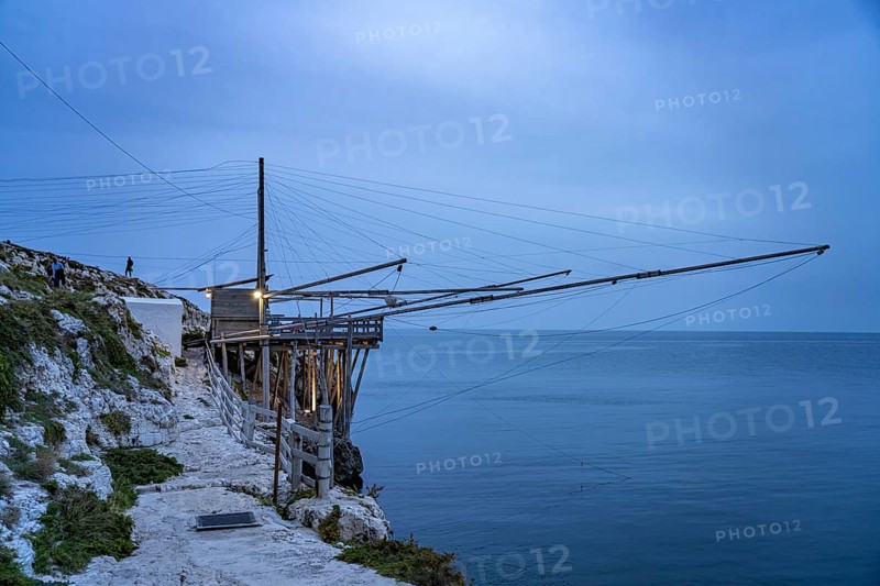 Historic pile dwelling of the fishermen Trabucco on the coast of Vieste at dusk, Gargano, Apulia, Italy