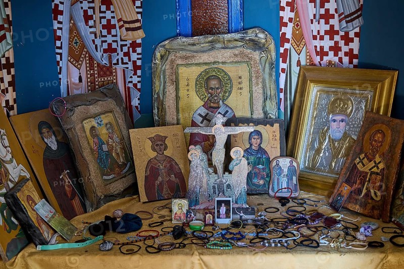 Table full of orthodox icons of various saints in an interior, Agios Nikolaos Chapel, harbour, Kolymbia, Rhodes, Dodecanese, Greek Islands, Greece