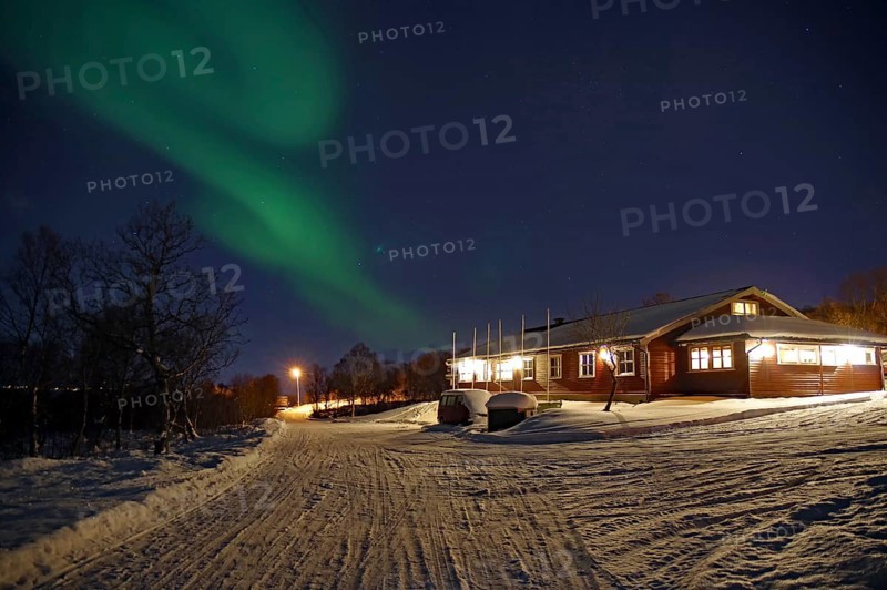 A snowy path leads to a house under the Northern Lights and a clear night sky, Sortland campsite, Vesteralen, Nordland, Arctic, Norway