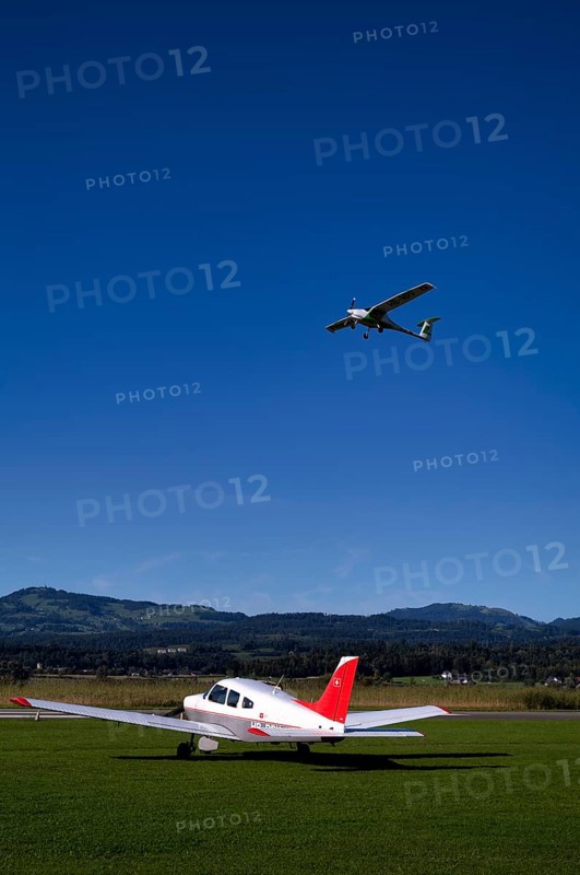 Pipistrel Velis Club with aircraft registration HB-NPP taking off over Piper Archer II HB-PPY on the ground, Wangen-Lachen airfield, LSPV, Canton Schwyz, Switzerland
