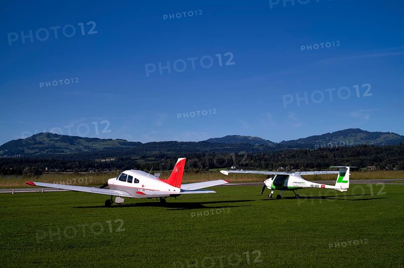 Pipistrel Velis Club on the right with aircraft registration HB-NPP stands next to Piper Archer II HB-PPY on the left on the ground, Wangen-Lachen airfield, LSPV, Canton Schwyz, Switzerland