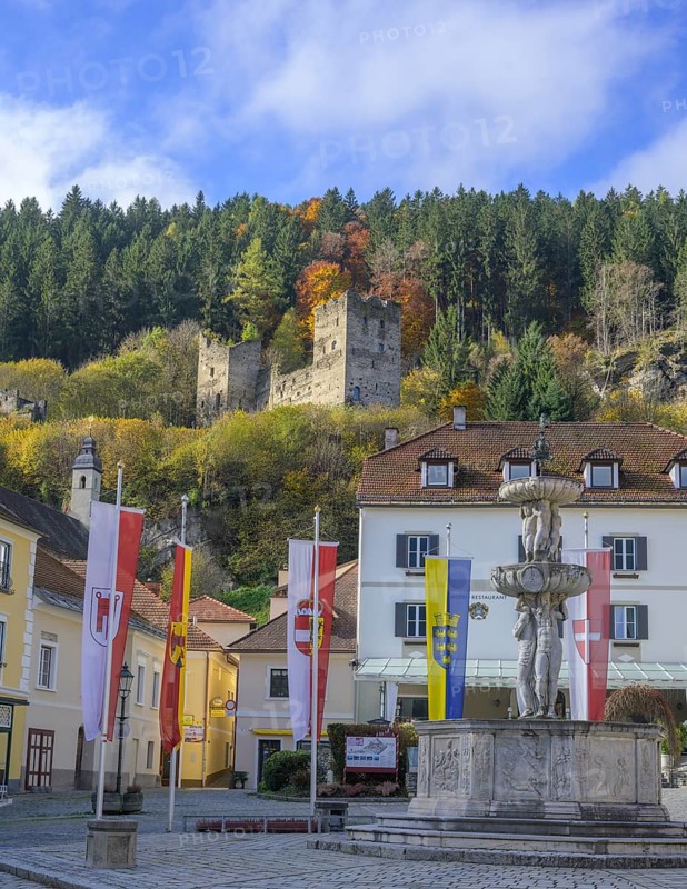 Main square with fountain behind castle ruins, Friesach, Carinthia, Austria