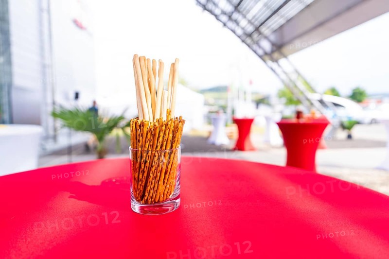 A jar of breadsticks stands on a red table at an outdoor event, Lake Constance, Germany