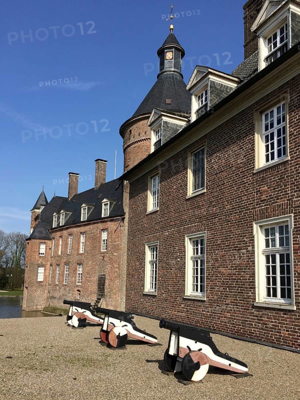 View of small cannons in front of right part of outer bailey building, left in background part of main castle building and top of keep tower, moated castle moated castle Anholt, Isselburg, North Rhine-Westphalia, Germany