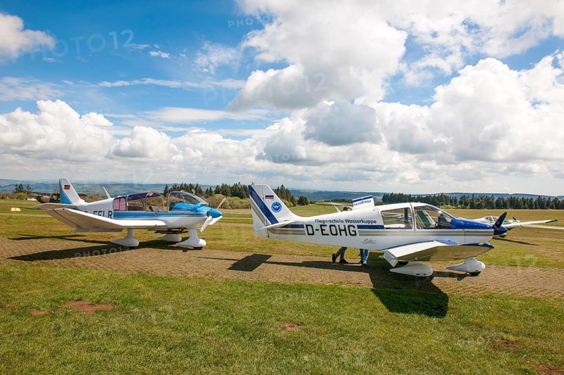 View of two single-engine cantilever low-wing propeller aircraft Light aircraft left type Robin DR.400-180R Remorqueur towing aircraft for glider pilots, right Robin DR400-180 Regent suitable as towing aircraft for glider pilots in parking position on apron of Wasserkuppe airfield, Gersfeld, district of Fulda, Hesse, Germany