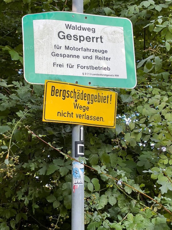 Below warning sign in mountain damage area with mountain damage Do not leave paths Above prohibition sign due to nature conservation Forest path closed for motor vehicles Carriages and riders free for forestry operations, Schellenberger Wald, Essen, North Rhine-Westphalia, Germany