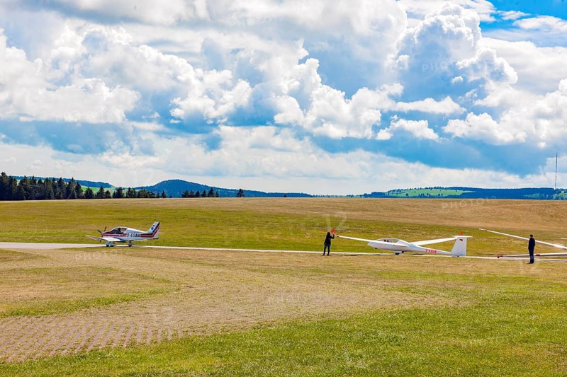 View of left single-engine light aircraft Robin DR400 as tow plane for right glider Glider pilots standing on runway of Wasserkuppe airfield, Gersfeld, district of Fulda, Hesse, Germany, just in front of take-off