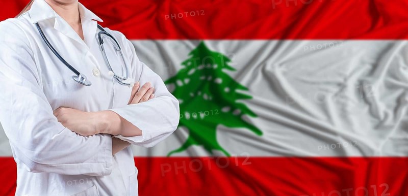 Doctor with crossed arms on Lebanon flag. Lebanese health and care concept. Female doctor on Lebanon flag