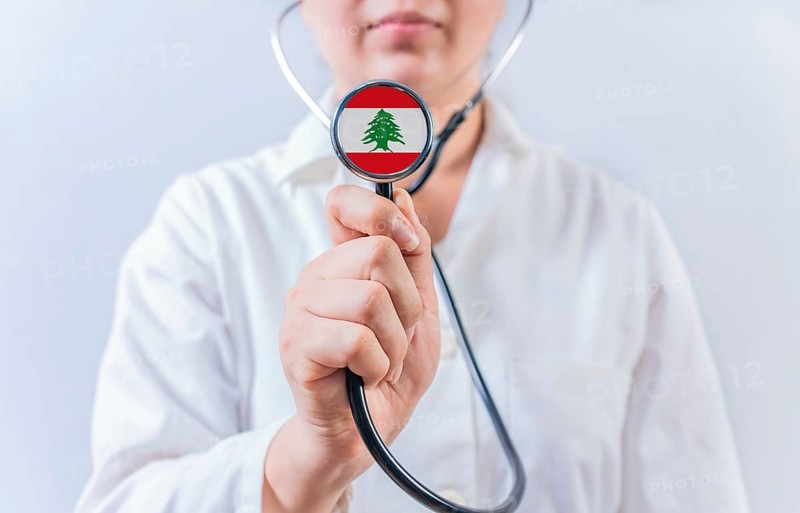 Female doctor holding stethoscope with Lebanon flag. National health system of Lebanon