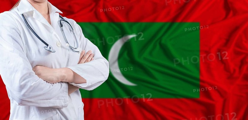 Doctor with crossed arms on Maldives flag. Maldivian health and care concept. Female doctor on Maldives flag