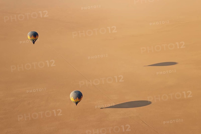 Two hot-air balloons above an arid plain at the edge of the Namib Desert. Aerial view from another balloon. Namibia