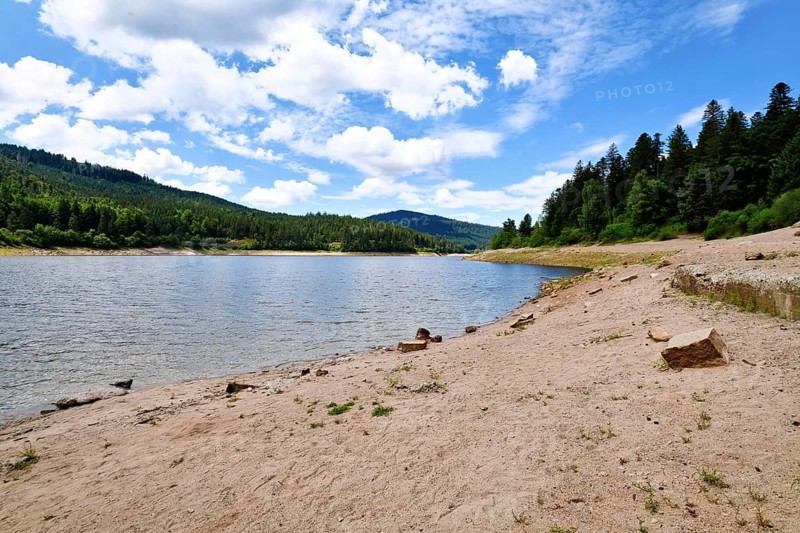 Beautiful mountain lake in the Black Forest in Forbach in Germany called Schwarzenbach Reservoir surrounded by forested hills under a clear sky