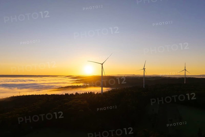 Three wind turbines overlook a fog-covered forest at sunrise, near Schorndorf, Rems-Murr district, Rems-Murr-Kreis, Baden-Württemberg, Germany