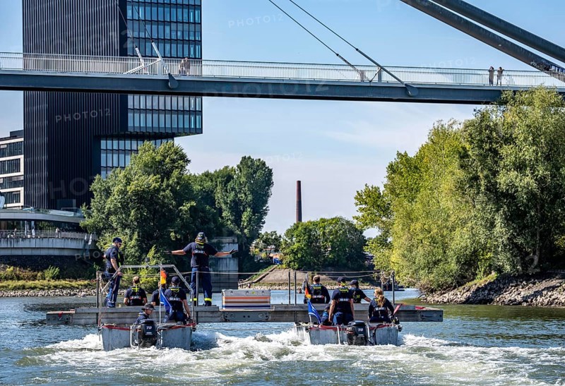 Exercise run of a multi-purpose pontoon on the Rhine, Medienhafen, the skipper gives instructions to the two helmsmen by hand signal, the specialist group for water hazards, in Düsseldorf, the motorised pontoon can be used as a ferry for people or equipment, as a working platform or bridge, during the major exercise FÜLEX25, lasting several days, of the THW, Technisches Hilfswerk, Landesverband North Rhine-Westphalia, over 3500 volunteers from the 127 North Rhine-Westphalia local associations practise many different scenarios over 4 weekends