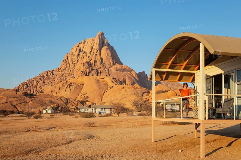 The isolated Spitzkoppe mountain (1728 m) provides a dramatic backdrop for the chalets of the upmarket Spitzkoppen Lodge. Damaraland, Namibia