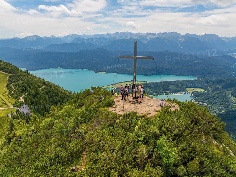 People on the summit with a cross, in the background a wide panoramic view, Herzogstand summit, Walchensee, Schlehdorf, Germany
