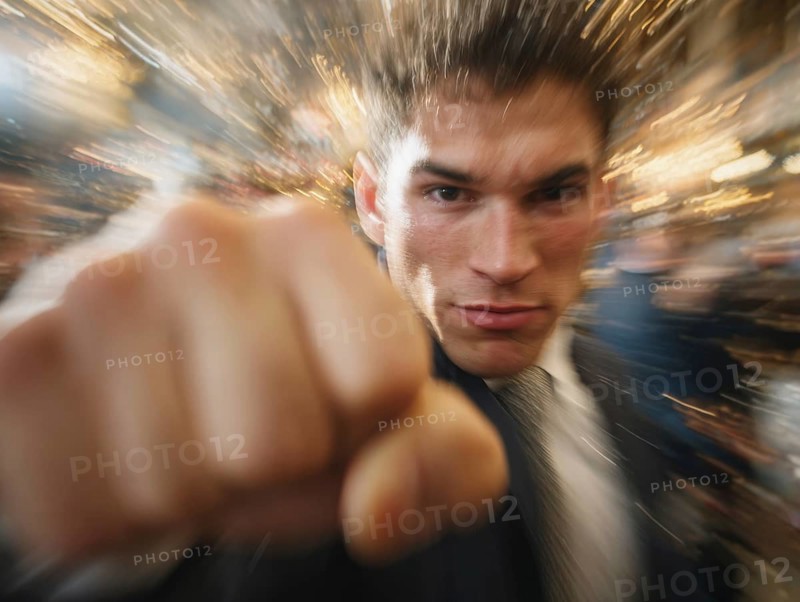 A man shows an outstretched fist to the camera while the background blurs into motion, symbolic image for physical altercation in public, use of force, physical violence, act of violence, aggressive behaviour, brawl, AI generated