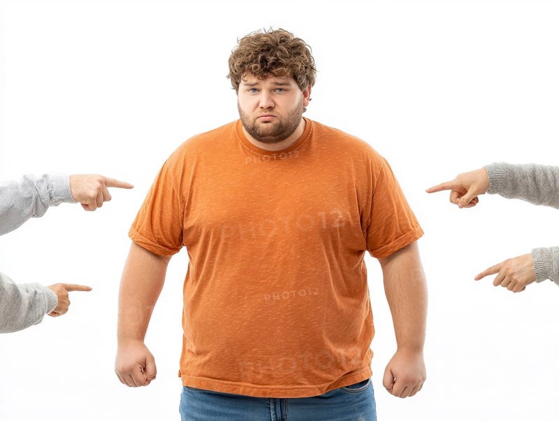 Overweight boy being judged by pointing fingers, symbolising fatshaming, bullying, judgement and discrimination based on his body weight. The image powerfully conveys the sense of shame, isolation and psychological distress associated with bullying and prejudice against obesity, AI generated