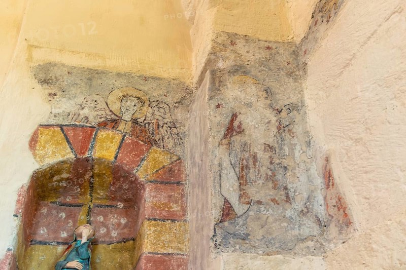 Saint Jean Chapel features ancient wall paintings showcasing religious figures with vibrant colors and intricate details. Champeix village. Puy de Dome. Auvergne Rhone Alpes. France