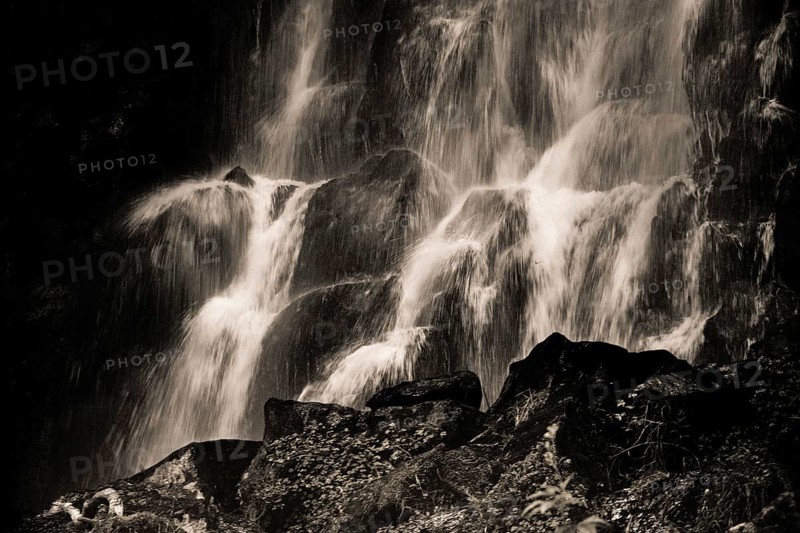 Vaucoux waterfall cascades gracefully over dark rocks, surrounded by lush greenery, Auvergne Volcanoes Regional Park, Puy de Dome., Auvergne-Rhone-Alpes, France