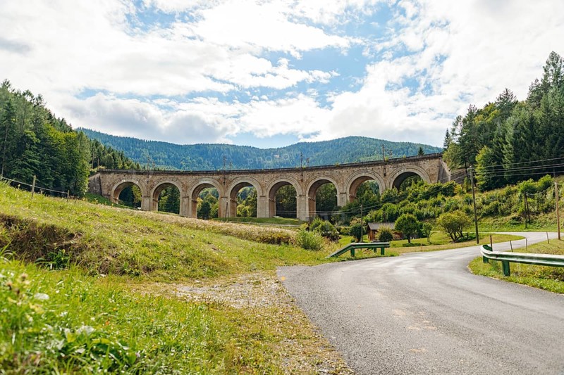 Adlitzgraben Viaduct, cloudy sky and green hills, Semmering Railway, Semmering, Lower Austria, Austria
